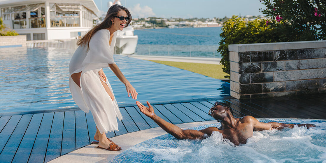 A couple relaxing by the pool in the Hamilton Princess Bermuda